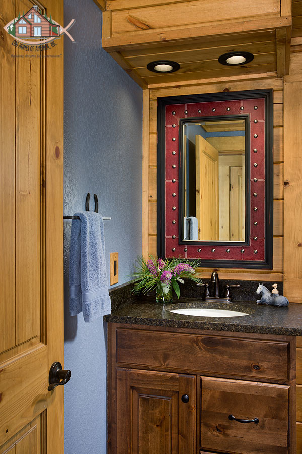 Diseño de cuarto de baño rústico de tamaño medio con lavabo bajoencimera, armarios con paneles con relieve, puertas de armario de madera en tonos medios, encimera de granito, sanitario de una pieza, paredes azules, suelo de baldosas de cerámica y aseo y ducha