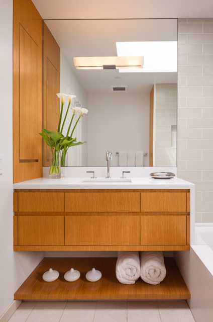 Inspiration for a small contemporary ensuite bathroom in San Francisco with a submerged sink, flat-panel cabinets, medium wood cabinets, engineered stone worktops, a submerged bath, a shower/bath combination, a one-piece toilet, grey tiles, ceramic tiles, white walls and limestone flooring.