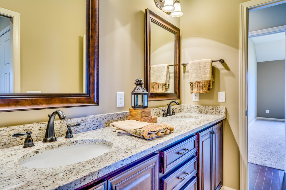 Bathroom - mid-sized traditional beige floor bathroom idea in Other with raised-panel cabinets, medium tone wood cabinets, beige walls, an undermount sink and granite countertops