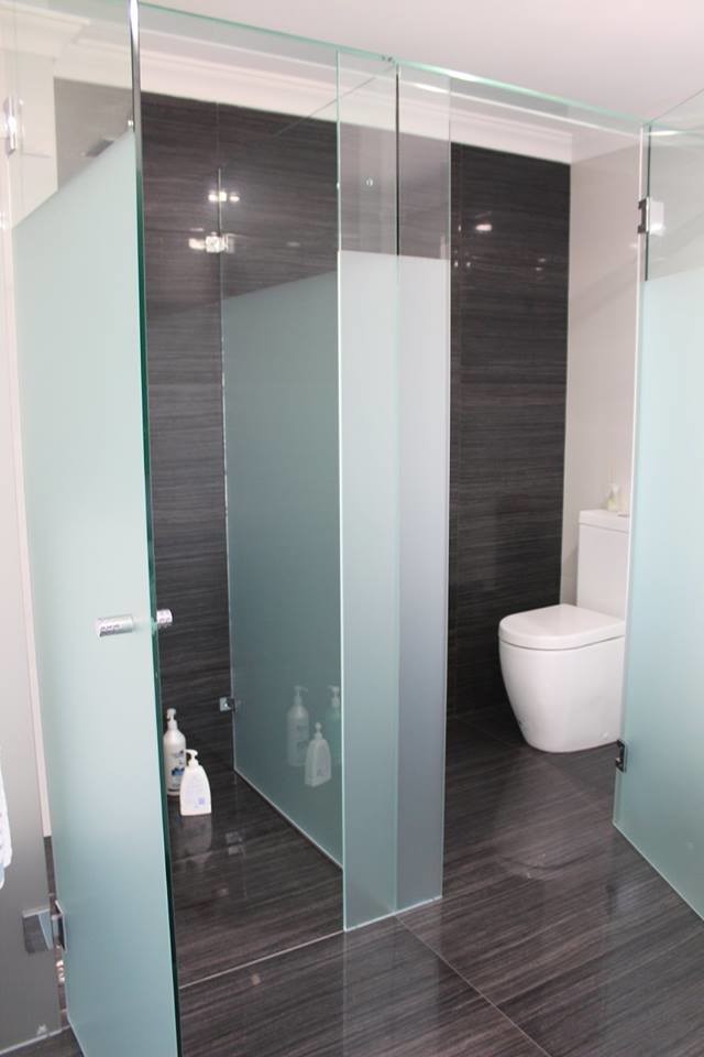 Foto de cuarto de baño actual sin sin inodoro con sanitario de dos piezas, paredes grises y ducha con puerta con bisagras