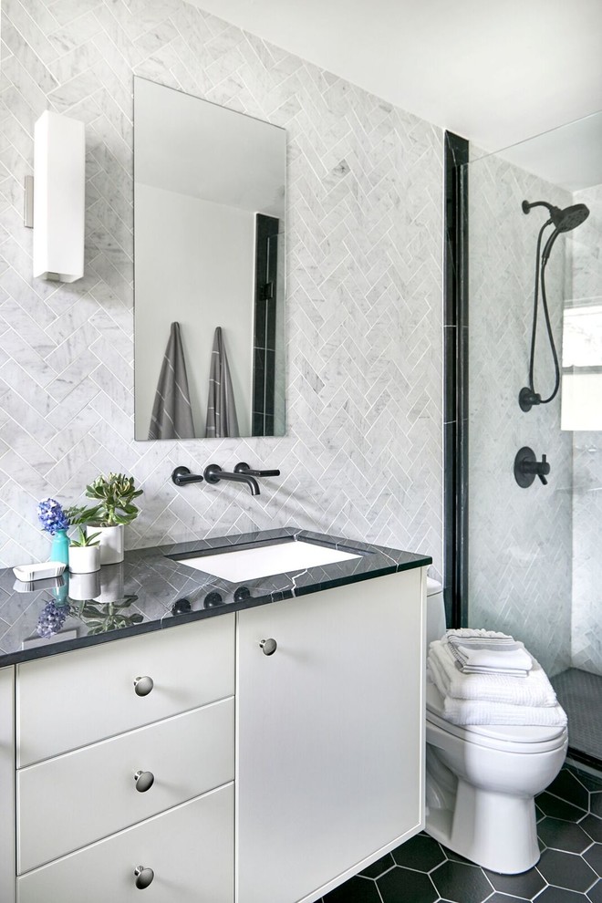 Idéer för att renovera ett litet funkis badrum med dusch, med släta luckor, vita skåp, en dusch i en alkov, en toalettstol med hel cisternkåpa, grå kakel, marmorkakel, vita väggar, skiffergolv, marmorbänkskiva och ett undermonterad handfat