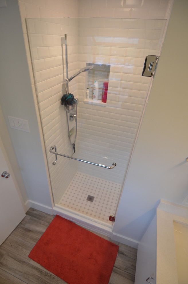Small contemporary ensuite bathroom in Houston with flat-panel cabinets, white cabinets, an alcove shower, a two-piece toilet, white tiles, porcelain tiles, white walls, porcelain flooring, a submerged sink and engineered stone worktops.