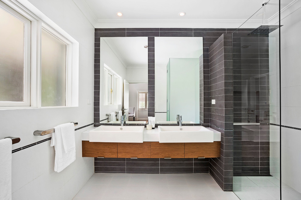 Example of a mid-sized trendy master gray tile and mosaic tile ceramic tile alcove shower design in Sydney with light wood cabinets, white walls, a wall-mount sink and limestone countertops
