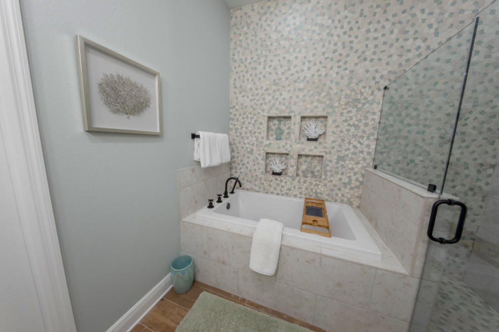 Cette photo montre une salle de bain bord de mer avec une baignoire posée, une douche ouverte, un carrelage vert, un carrelage de pierre, un mur bleu, un sol en carrelage de céramique, un sol marron, une cabine de douche à porte battante, des toilettes cachées, meuble double vasque et meuble-lavabo encastré.
