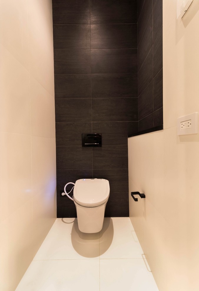 Exemple d'un WC et toilettes moderne avec un placard à porte plane, des portes de placard blanches, WC à poser, un carrelage blanc, des carreaux de porcelaine, un mur gris, un sol en carrelage de porcelaine, un lavabo encastré, un plan de toilette en acier inoxydable, un sol blanc et un plan de toilette noir.