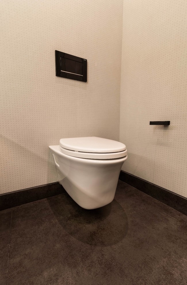 Modern inredning av ett svart svart toalett, med släta luckor, vita skåp, en toalettstol med hel cisternkåpa, vit kakel, porslinskakel, grå väggar, klinkergolv i porslin, ett undermonterad handfat, bänkskiva i rostfritt stål och vitt golv