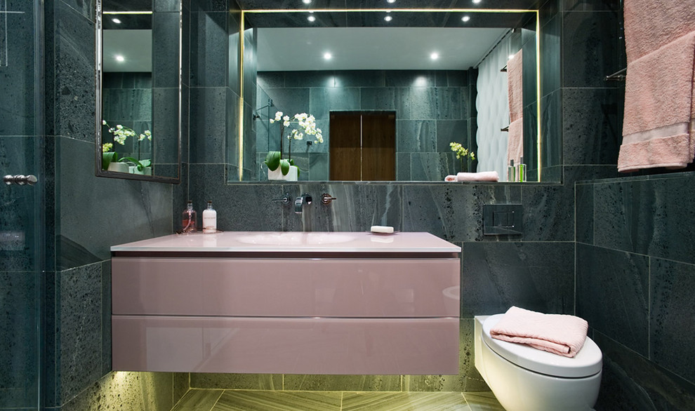 ロンドンにある小さなコンテンポラリースタイルのおしゃれなマスターバスルーム (コンソール型シンク、ガラス扉のキャビネット、ドロップイン型浴槽、壁掛け式トイレ、緑のタイル、セラミックタイル、ベージュの壁、セラミックタイルの床、赤いキャビネット) の写真