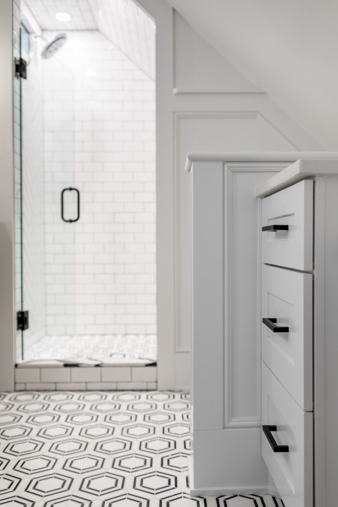 Пример оригинального дизайна: большая главная ванная комната в стиле неоклассика (современная классика) с плоскими фасадами, светлыми деревянными фасадами, угловым душем, раздельным унитазом, белой плиткой, керамической плиткой, белыми стенами, мраморным полом, подвесной раковиной, столешницей из плитки, черным полом, душем с распашными дверями, белой столешницей, сиденьем для душа, тумбой под две раковины, подвесной тумбой и панелями на стенах