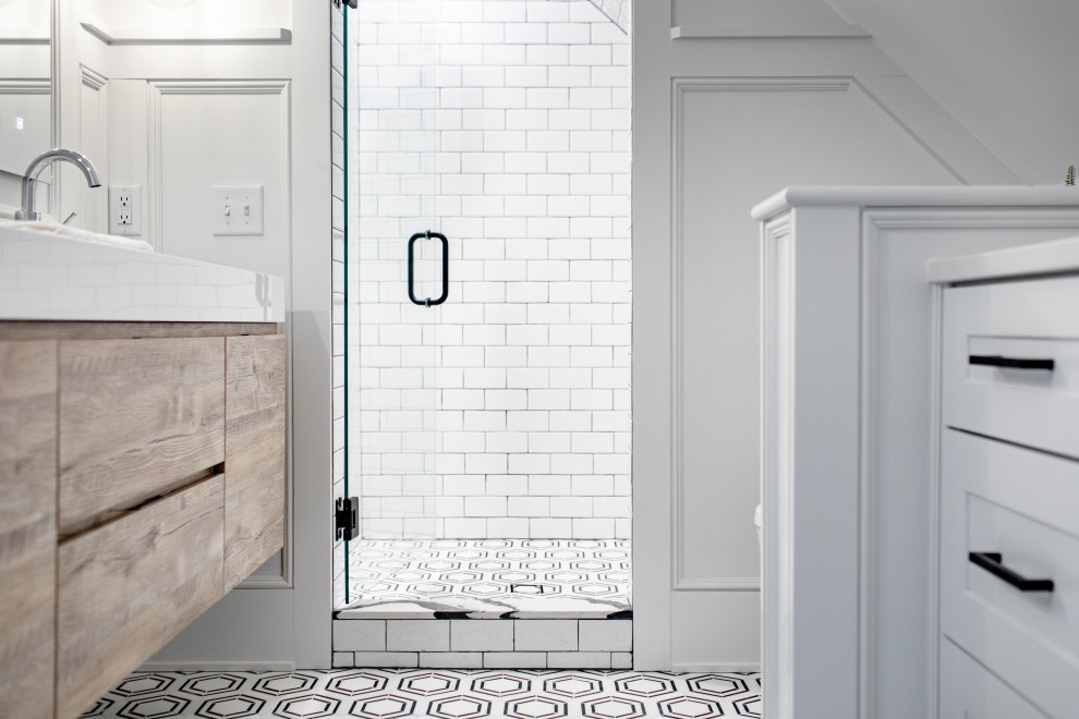 Example of a large transitional master white tile and ceramic tile marble floor, black floor, double-sink and wainscoting bathroom design in Minneapolis with flat-panel cabinets, light wood cabinets, a two-piece toilet, white walls, a wall-mount sink, tile countertops, a hinged shower door, white countertops and a floating vanity