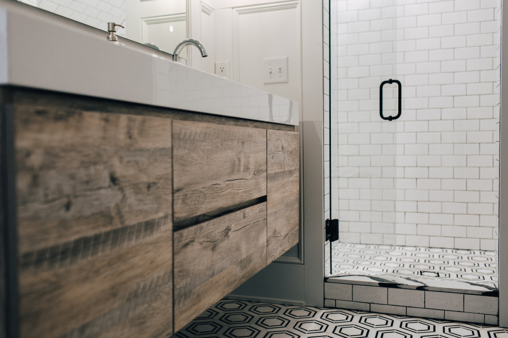 На фото: большая главная ванная комната в стиле неоклассика (современная классика) с плоскими фасадами, светлыми деревянными фасадами, угловым душем, раздельным унитазом, белой плиткой, керамической плиткой, белыми стенами, мраморным полом, подвесной раковиной, столешницей из плитки, черным полом, душем с распашными дверями, белой столешницей, сиденьем для душа, тумбой под две раковины, подвесной тумбой и панелями на стенах с