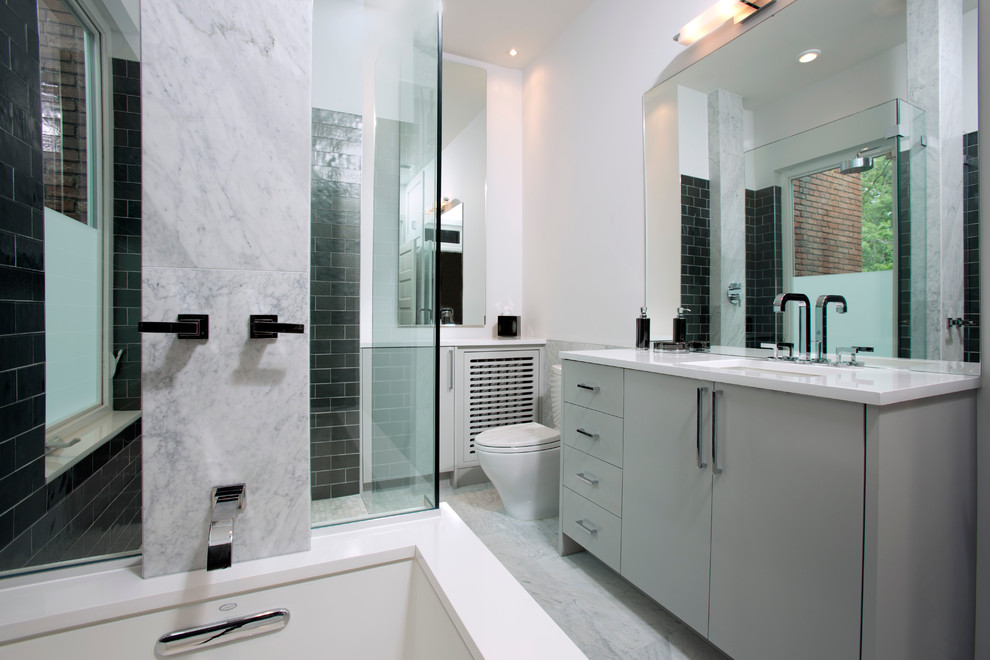 Example of a mid-sized trendy master black tile, gray tile, white tile and stone tile marble floor bathroom design in DC Metro with flat-panel cabinets, gray cabinets, a one-piece toilet, white walls, an undermount sink and solid surface countertops