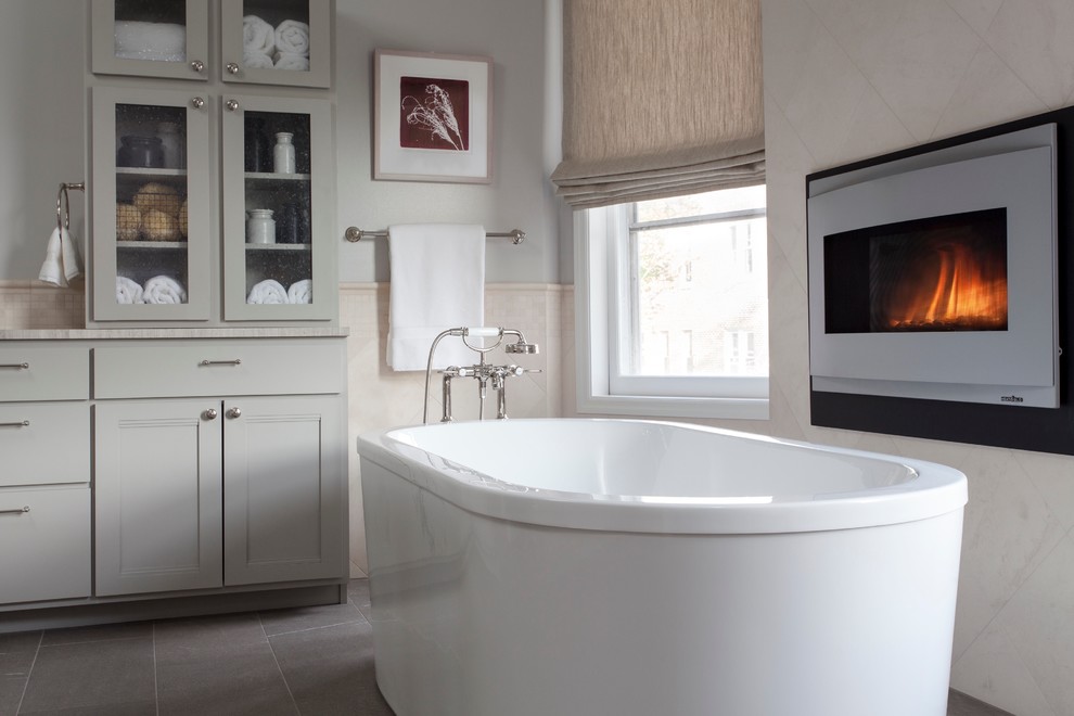 Inspiration for a large traditional ensuite bathroom in DC Metro with glass-front cabinets, grey cabinets, a freestanding bath, grey tiles, white walls and marble worktops.