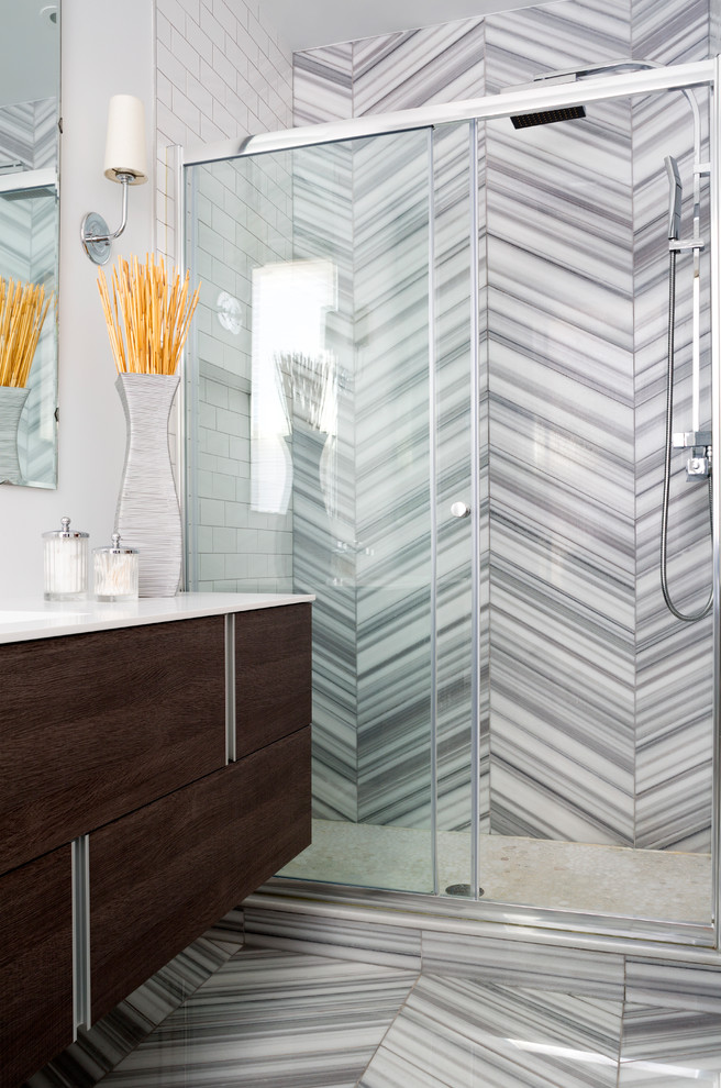 This is an example of a medium sized classic shower room bathroom in DC Metro with flat-panel cabinets, dark wood cabinets, an alcove shower, a one-piece toilet, metro tiles, white walls, an integrated sink, solid surface worktops and grey tiles.