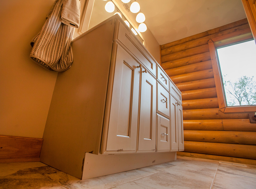 Foto di una stanza da bagno stile rurale di medie dimensioni con ante lisce, ante bianche, pareti beige, pavimento in gres porcellanato, lavabo integrato, top in marmo e pavimento beige