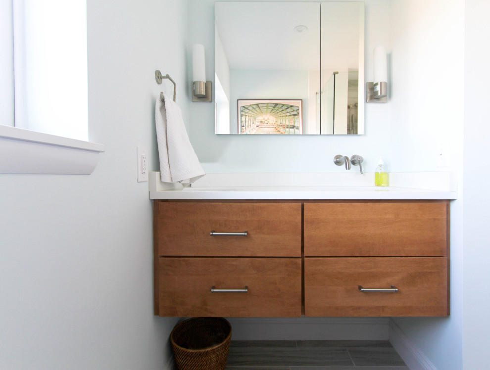 Inspiration for a medium sized modern ensuite bathroom in Philadelphia with flat-panel cabinets, medium wood cabinets, a corner shower, a two-piece toilet, multi-coloured tiles, white walls, terracotta flooring, a submerged sink, grey floors, a hinged door, white worktops, engineered stone worktops and glass tiles.