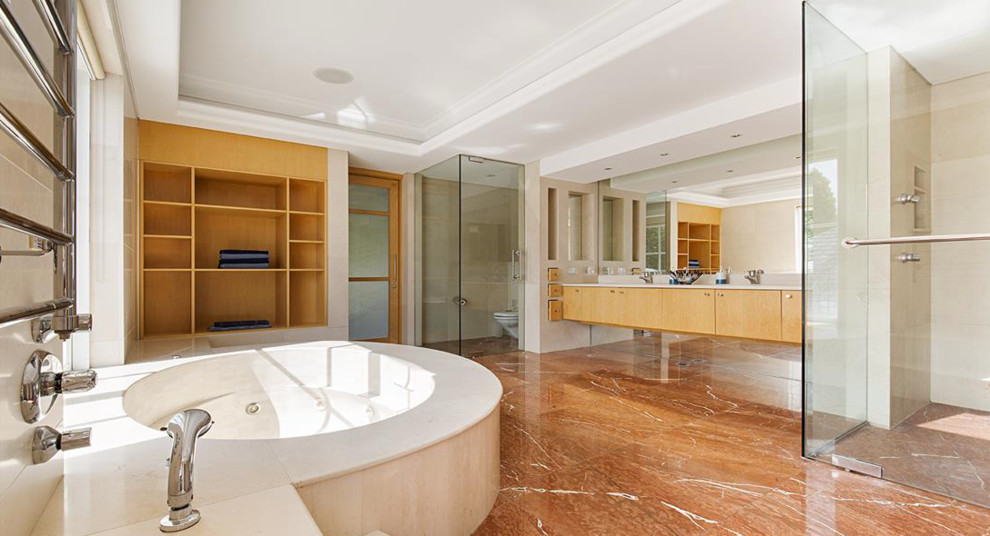 Réalisation d'une très grande salle de bain principale design en bois clair avec un bain bouillonnant, une douche d'angle, WC à poser, du carrelage en marbre, un mur blanc, un sol en marbre, un lavabo intégré, un plan de toilette en terrazzo, un sol beige et une cabine de douche à porte battante.