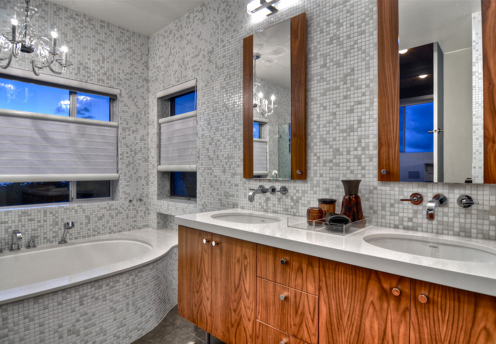 Ispirazione per una stanza da bagno minimal con lavabo sottopiano, ante lisce, ante in legno scuro, vasca sottopiano, piastrelle bianche e piastrelle a mosaico