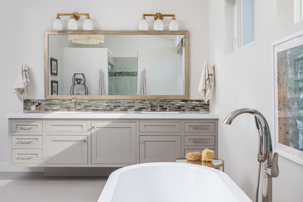 Inspiration for a coastal gray floor and double-sink freestanding bathtub remodel in Los Angeles with shaker cabinets, gray cabinets, gray walls, an undermount sink, white countertops and a built-in vanity