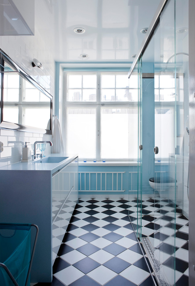 Shabby-Style Badezimmer mit Wandtoilette mit Spülkasten, weißen Fliesen, Porzellanfliesen, blauer Wandfarbe, Keramikboden, Unterbauwaschbecken, Mineralwerkstoff-Waschtisch, schwarzem Boden und blauer Waschtischplatte