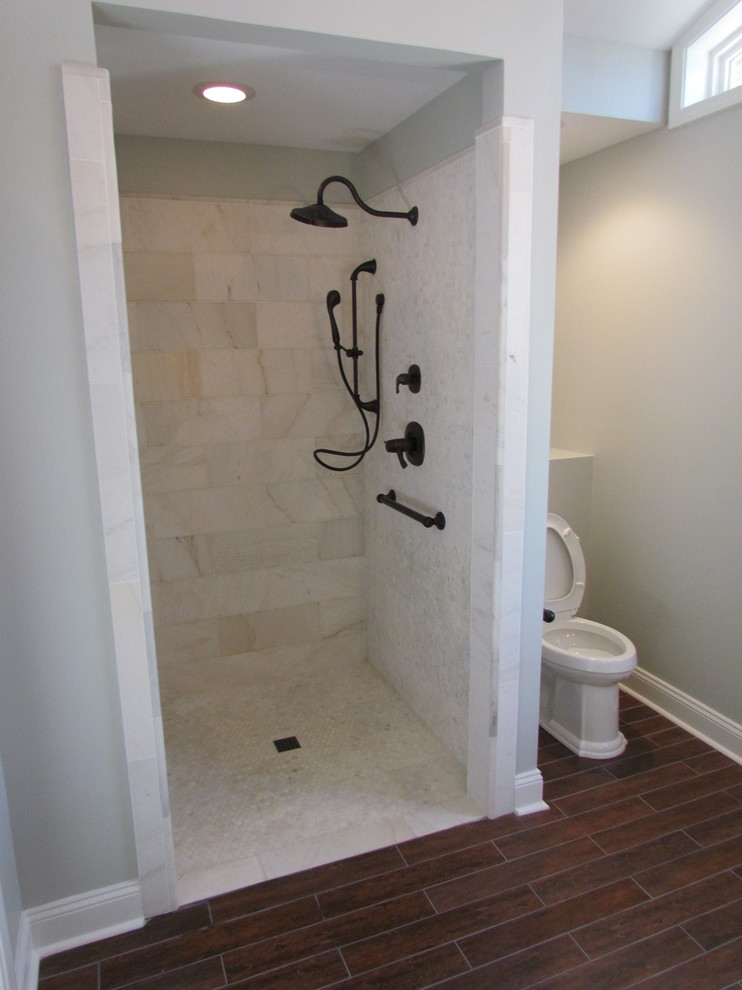 На фото: главная ванная комната среднего размера в классическом стиле с душем в нише, раздельным унитазом, серой плиткой, серыми стенами, полом из ламината, коричневым полом и душем с распашными дверями