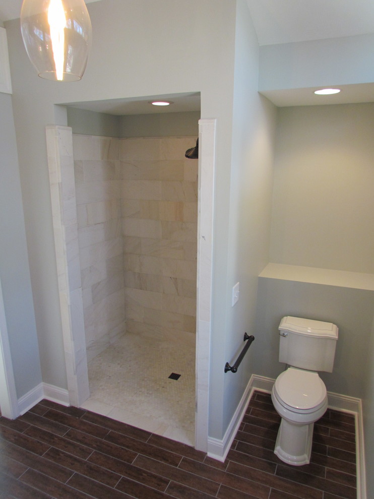 Idee per una stanza da bagno padronale tradizionale di medie dimensioni con doccia alcova, WC a due pezzi, piastrelle grigie, pareti grigie, pavimento in laminato, pavimento marrone e porta doccia a battente