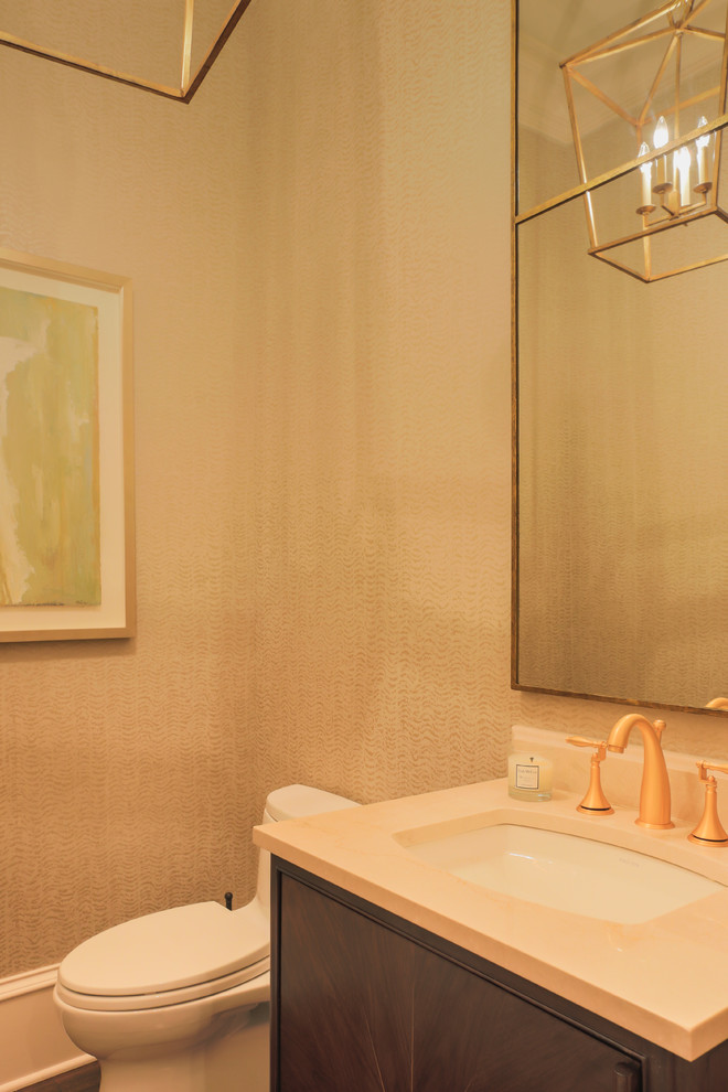 Esempio di una stanza da bagno classica di medie dimensioni con consolle stile comò, ante in legno bruno, WC monopezzo, pareti gialle, parquet scuro, lavabo sottopiano e top in marmo