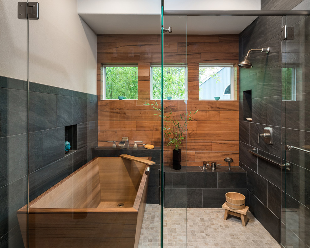 На фото: ванная комната в стиле неоклассика (современная классика) с отдельно стоящей ванной, душем в нише, черной плиткой, коричневой плиткой, керамогранитной плиткой, бежевыми стенами, полом из керамогранита, бежевым полом и душем с распашными дверями