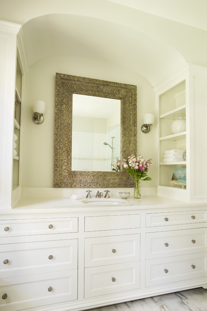 Inspiration pour une petite salle de bain principale traditionnelle avec un placard à porte shaker, des portes de placard blanches, une douche d'angle, WC à poser, un carrelage blanc, un carrelage de pierre, un mur beige, un sol en marbre, un lavabo encastré et un plan de toilette en quartz modifié.