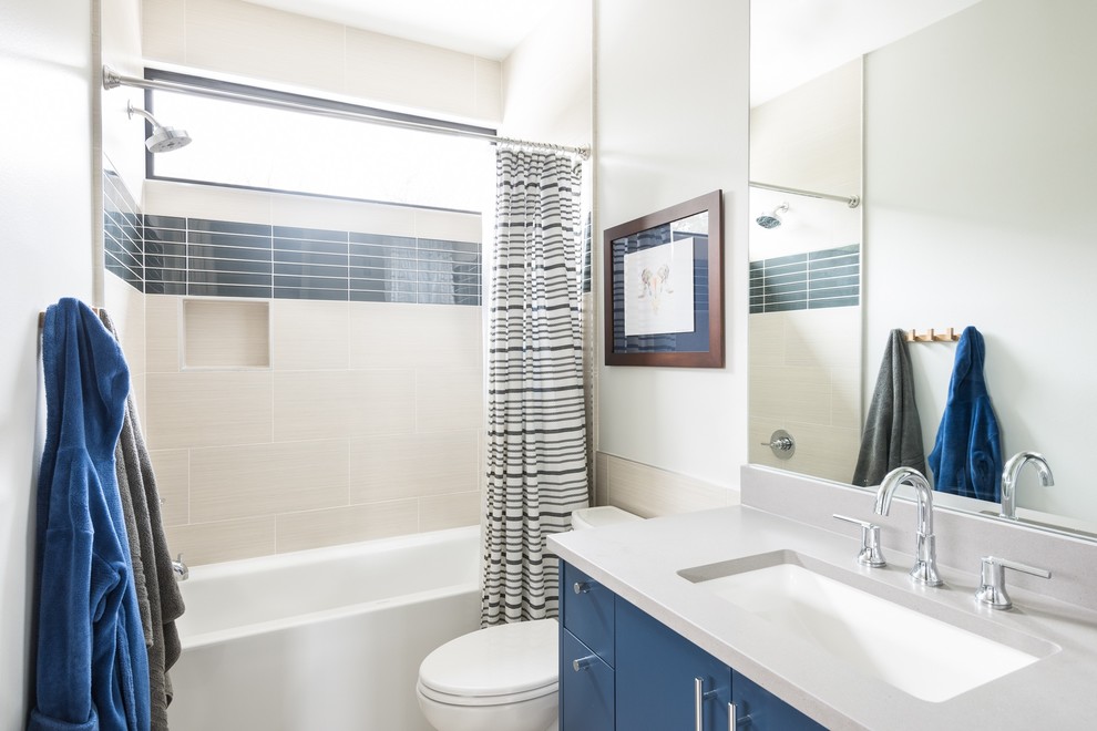 На фото: ванная комната в современном стиле с черными фасадами, ванной в нише, душем над ванной, бежевой плиткой, белыми стенами, врезной раковиной и шторкой для ванной с