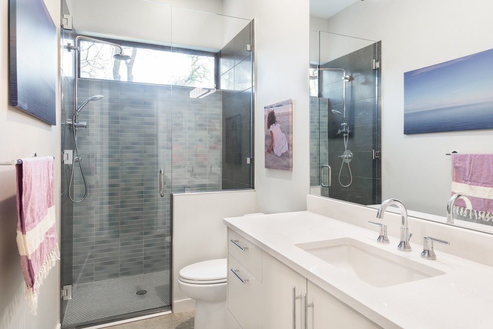 オースティンにあるコンテンポラリースタイルのおしゃれなお風呂の窓 (フラットパネル扉のキャビネット、白いキャビネット、アルコーブ型シャワー、グレーのタイル、白い壁、アンダーカウンター洗面器、開き戸のシャワー) の写真