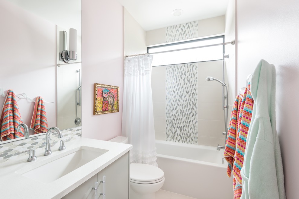 Exemple d'une salle de bain tendance avec un placard à porte plane, des portes de placard grises, une baignoire en alcôve, un combiné douche/baignoire, un carrelage gris, mosaïque, un mur rose, un lavabo encastré et une cabine de douche avec un rideau.