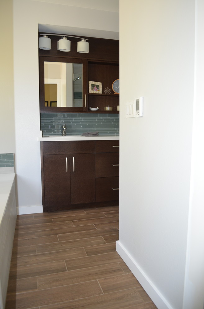 Medium sized contemporary ensuite bathroom in Seattle with a submerged sink, flat-panel cabinets, dark wood cabinets, engineered stone worktops, a submerged bath, an alcove shower, a one-piece toilet, grey tiles, ceramic tiles, grey walls, porcelain flooring, brown floors and a hinged door.
