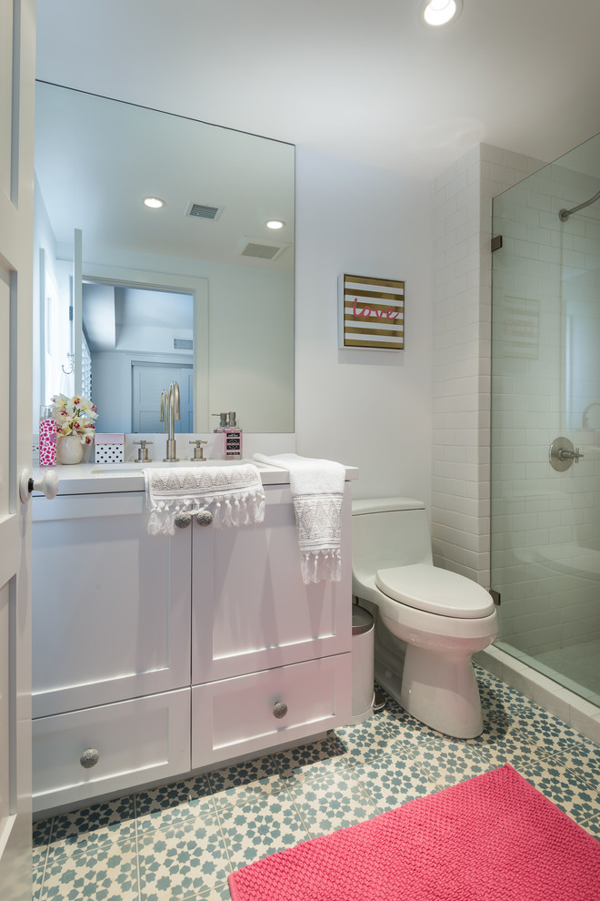 Photo of a medium sized midcentury shower room bathroom in Los Angeles with shaker cabinets, white cabinets, an alcove shower, a one-piece toilet, white tiles, metro tiles, white walls, cement flooring, a submerged sink, engineered stone worktops, multi-coloured floors and a shower curtain.