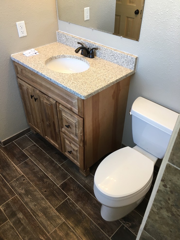 Example of a small mountain style master brown tile and ceramic tile ceramic tile walk-in shower design in Other with medium tone wood cabinets, a two-piece toilet, brown walls, an undermount sink and granite countertops