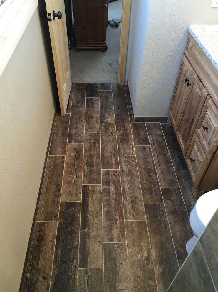 Inspiration for a small rustic master brown tile and ceramic tile ceramic tile walk-in shower remodel in Other with medium tone wood cabinets, a two-piece toilet, brown walls, an undermount sink and granite countertops