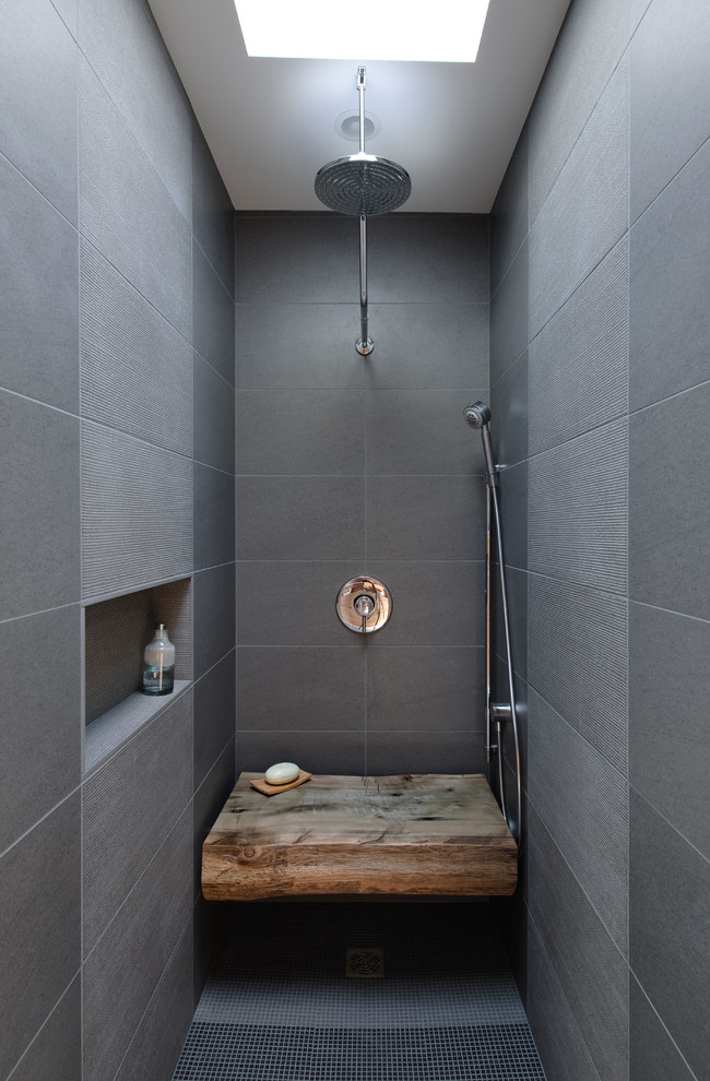 На фото: ванная комната в стиле лофт с душем в нише, серой плиткой и сиденьем для душа