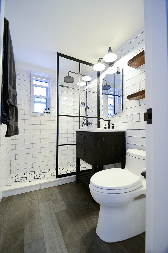 Inspiration for a mid-sized industrial white tile and subway tile porcelain tile and brown floor bathroom remodel in New York with furniture-like cabinets, brown cabinets, a one-piece toilet, white walls, a pedestal sink and white countertops
