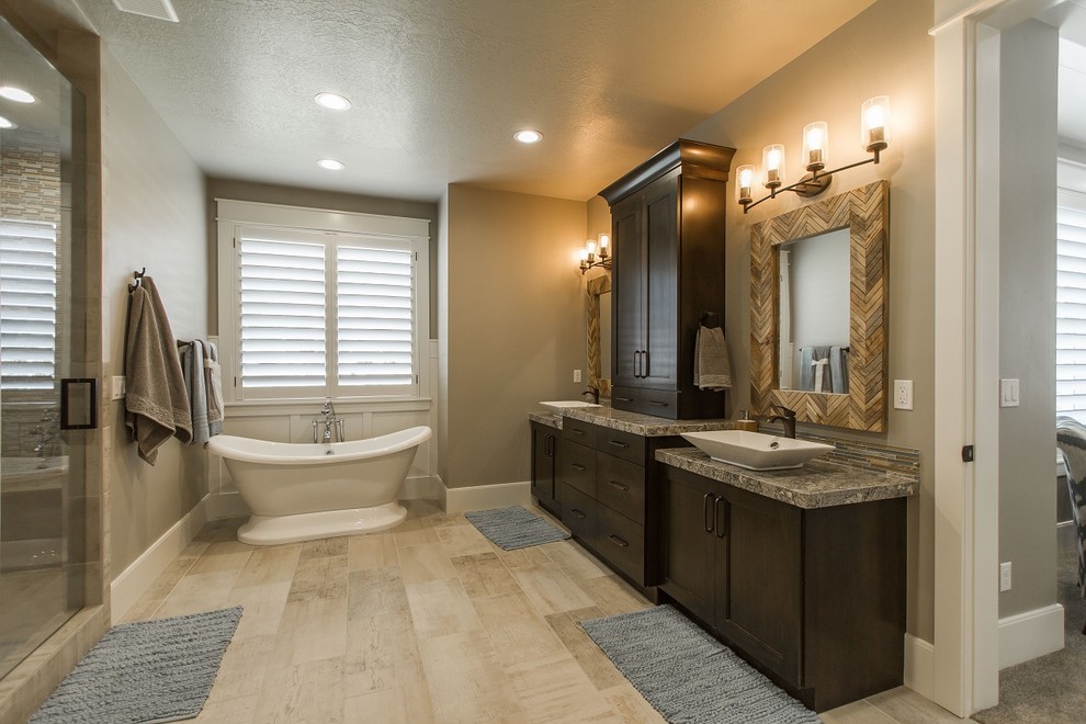 Foto på ett stort lantligt en-suite badrum, med skåp i shakerstil, skåp i mörkt trä, granitbänkskiva, ett fristående badkar, en dusch i en alkov, flerfärgad kakel och glaskakel