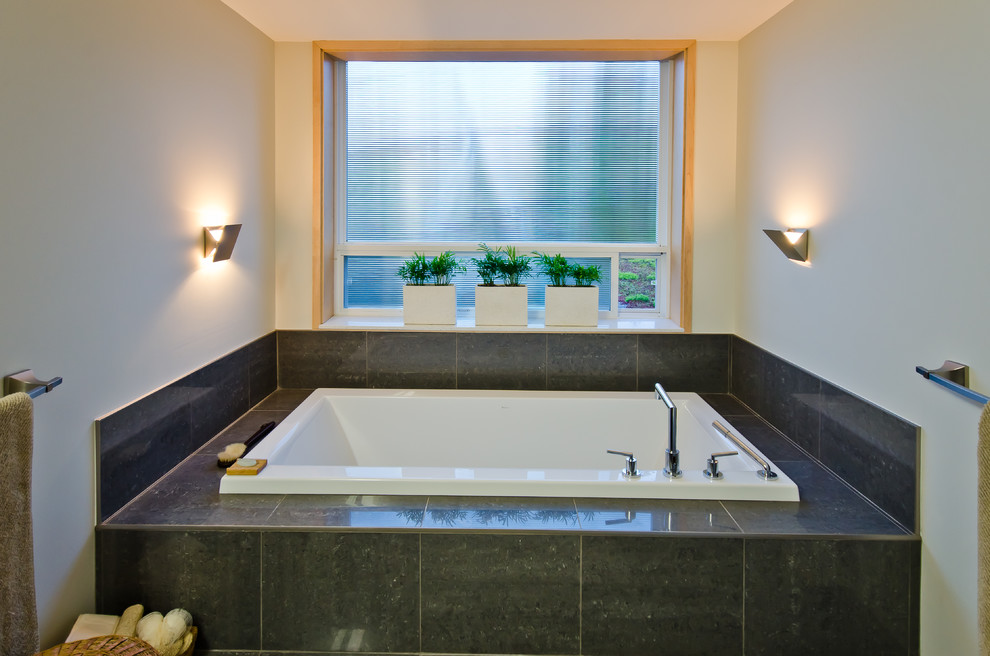Diseño de cuarto de baño contemporáneo con bañera encastrada y baldosas y/o azulejos grises