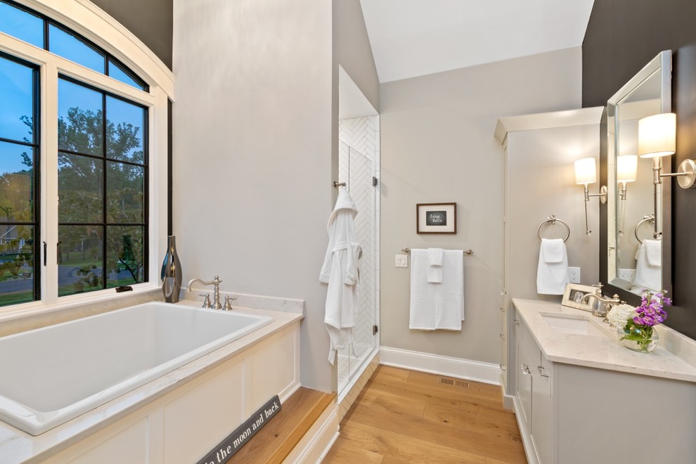 Exempel på ett mellanstort klassiskt vit vitt en-suite badrum, med släta luckor, grå skåp, ett japanskt badkar, vit kakel, keramikplattor, grå väggar, ljust trägolv, bänkskiva i kvarts och dusch med gångjärnsdörr