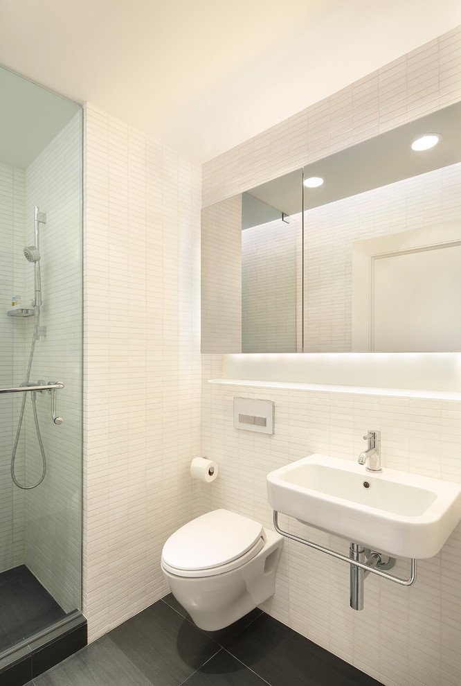 Idéer för ett litet modernt badrum med dusch, med ett väggmonterat handfat, en dusch i en alkov, en vägghängd toalettstol, vit kakel, stenkakel och vita väggar