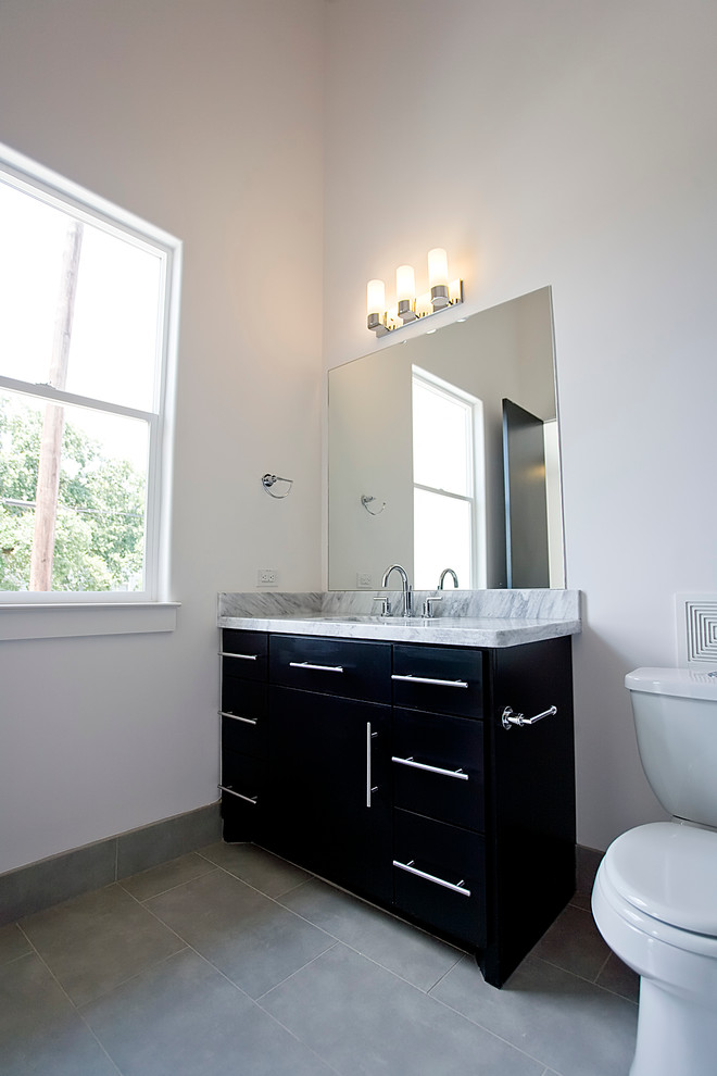 Medium sized modern family bathroom in Houston with a submerged sink, flat-panel cabinets, black cabinets, marble worktops, a walk-in shower, a two-piece toilet, grey tiles, porcelain tiles, white walls and porcelain flooring.