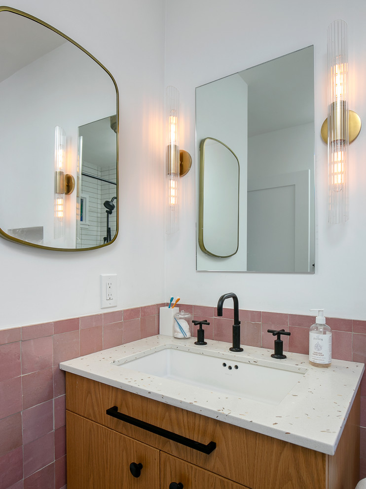 Пример оригинального дизайна: главная ванная комната среднего размера в стиле неоклассика (современная классика) с плоскими фасадами, светлыми деревянными фасадами, полновстраиваемой ванной, душем над ванной, раздельным унитазом, розовой плиткой, керамогранитной плиткой, белыми стенами, полом из цементной плитки, врезной раковиной, столешницей из искусственного камня, белым полом, шторкой для ванной и белой столешницей