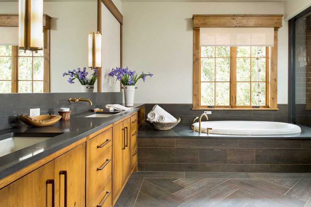 Idée de décoration pour une salle de bain principale chalet en bois brun avec un placard à porte plane, une baignoire posée, un mur blanc et un lavabo encastré.