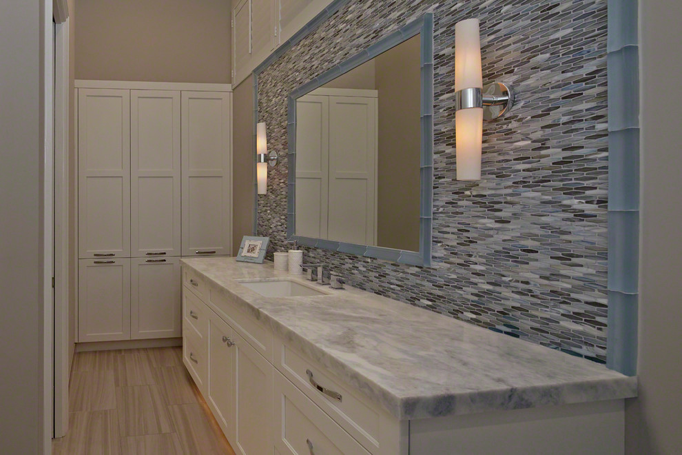 Foto på ett mellanstort funkis en-suite badrum, med luckor med infälld panel, vita skåp, blå kakel, stickkakel, beige väggar, ljust trägolv, ett undermonterad handfat och marmorbänkskiva
