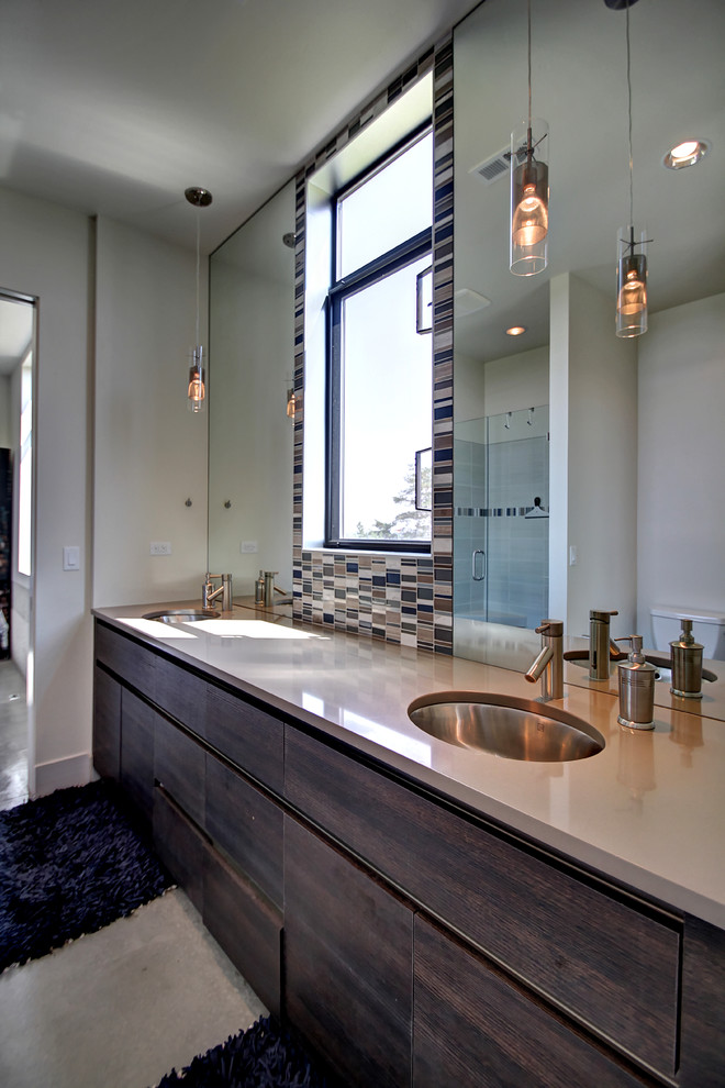 Réalisation d'une salle de bain principale design en bois foncé avec un placard à porte plane, un carrelage multicolore, un mur beige et un lavabo encastré.