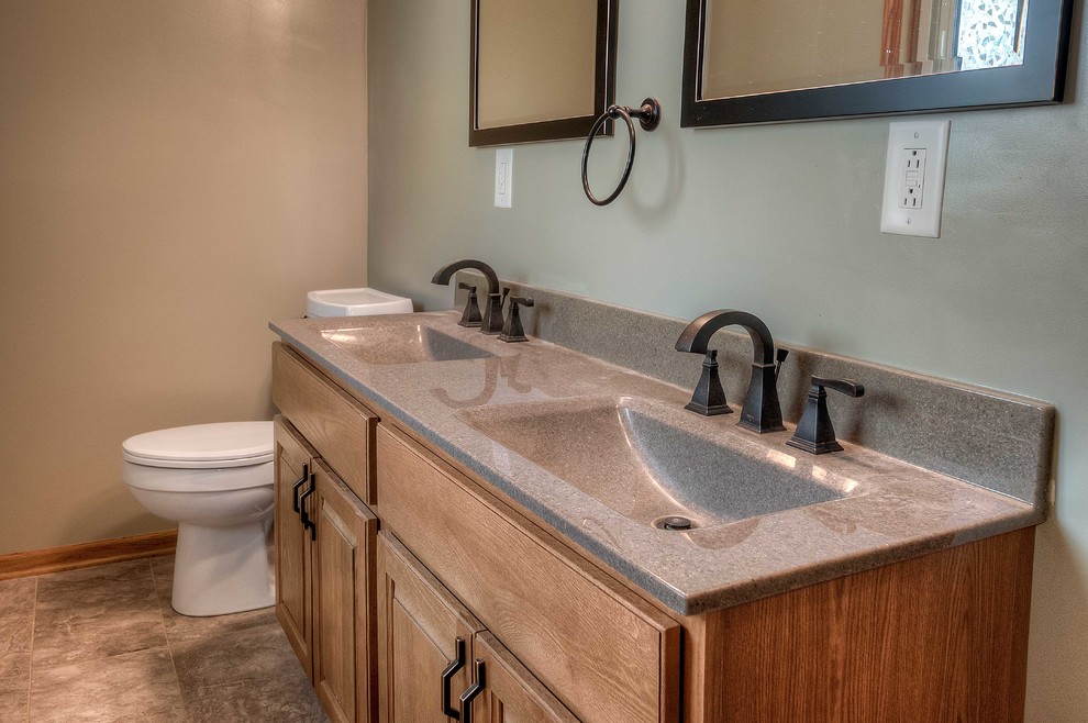 Inspiration for a mid-sized transitional master brown floor bathroom remodel in Omaha with raised-panel cabinets, medium tone wood cabinets, a one-piece toilet, beige walls, an integrated sink and onyx countertops