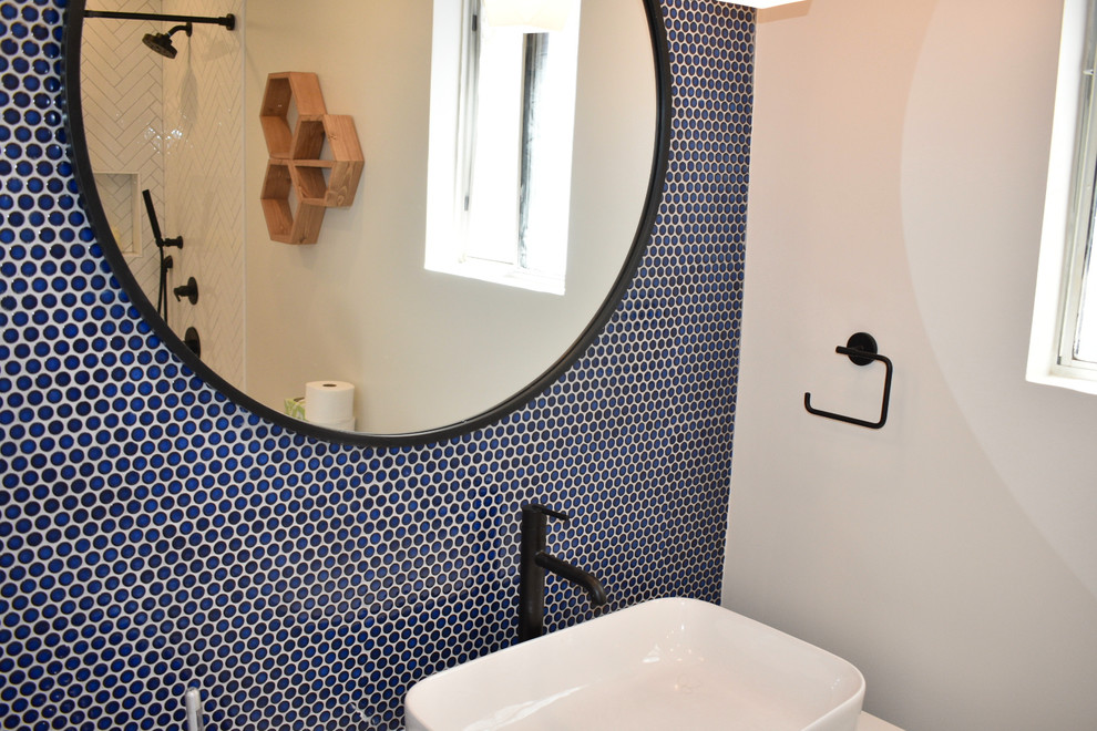 Cette image montre une salle de bain vintage en bois clair de taille moyenne pour enfant avec une baignoire posée, un carrelage bleu, des carreaux de porcelaine, un plan de toilette en quartz et un plan de toilette blanc.