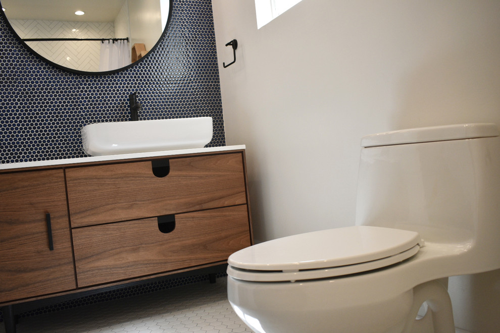 Aménagement d'une salle de bain rétro en bois clair de taille moyenne pour enfant avec une baignoire posée, un carrelage bleu, des carreaux de porcelaine, un plan de toilette en quartz et un plan de toilette blanc.