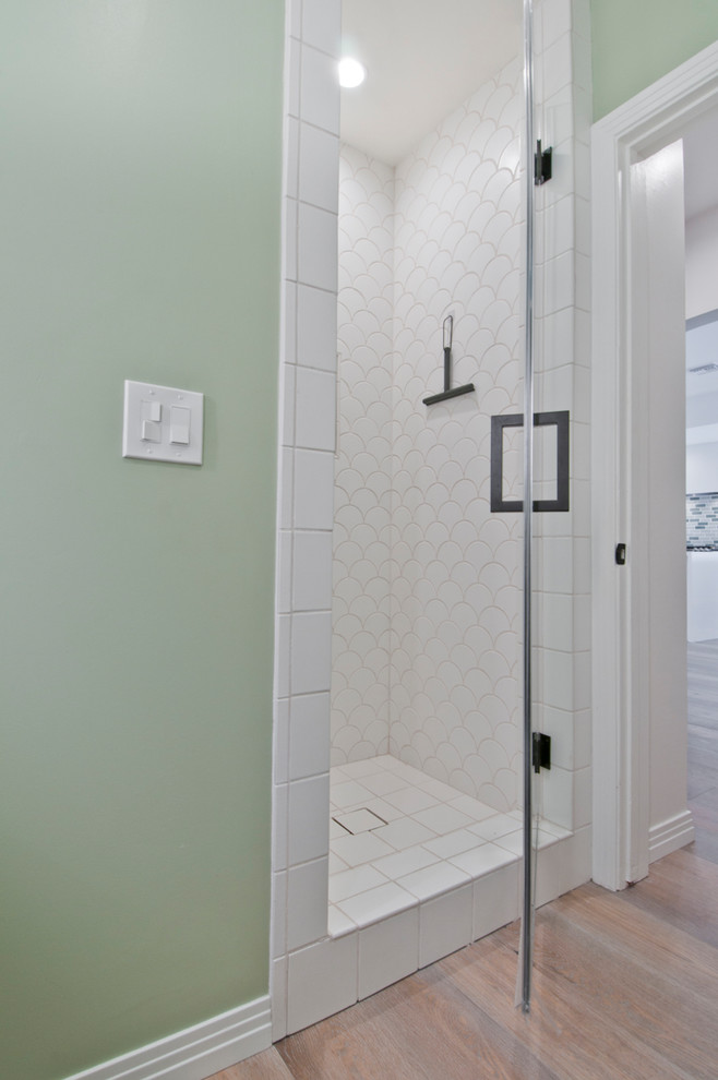Corner shower - mid-sized mid-century modern master green tile and ceramic tile corner shower idea in Los Angeles with furniture-like cabinets, medium tone wood cabinets, quartz countertops and a hinged shower door